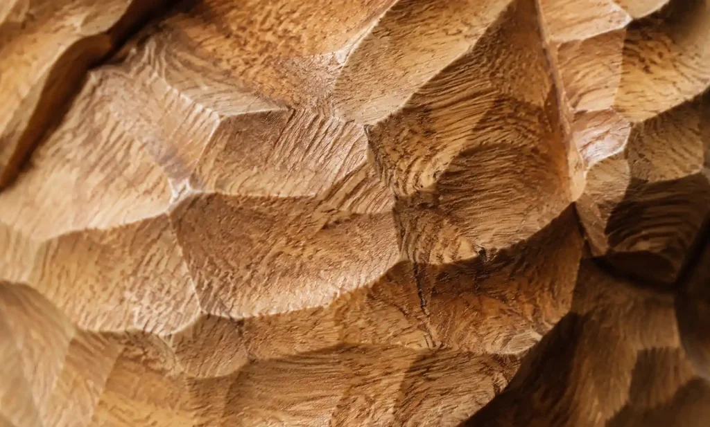 close up detail of hand carved wood showing artisan tool marks