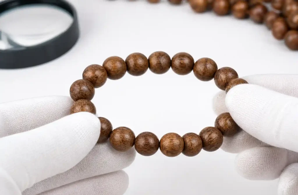 Quality control inspection of wooden bead bracelet showing craftsmanship detail